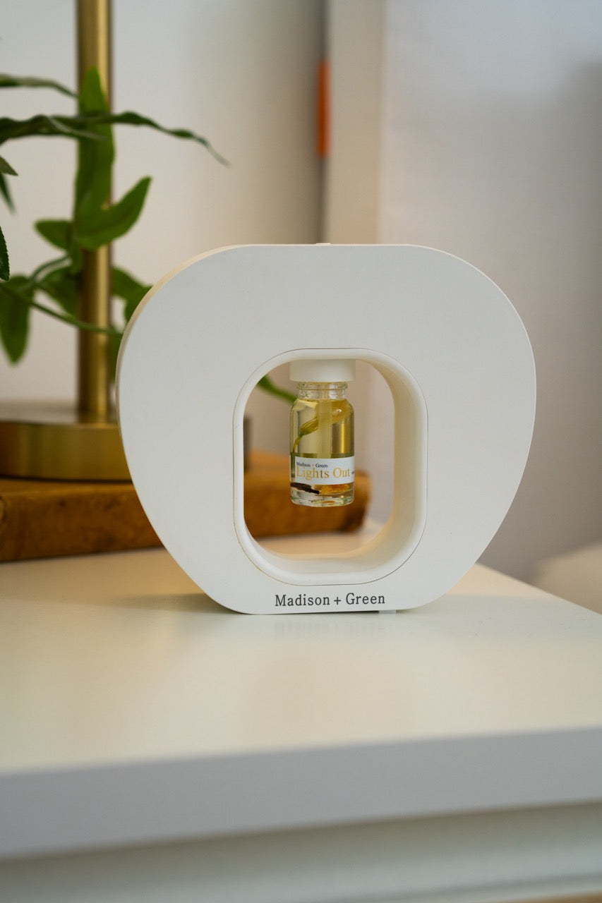 Nebulizing diffuser base with window showing glass bottle of light green oil
