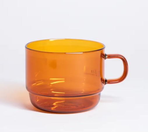 Orange glass stackable mug with curved handle and clear rim