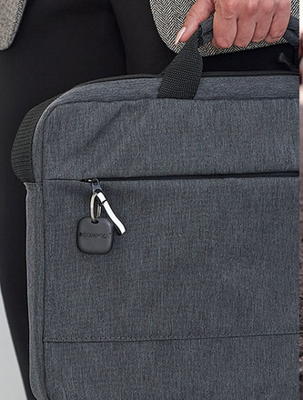 Key finder tag clipped to a gray backpack zipper pull area