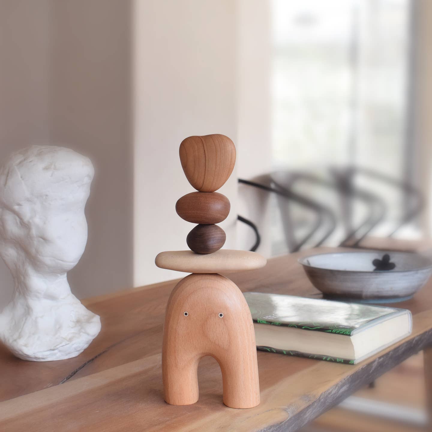 Wooden elf balancing stones figure, side view with light and dark stacked discs
