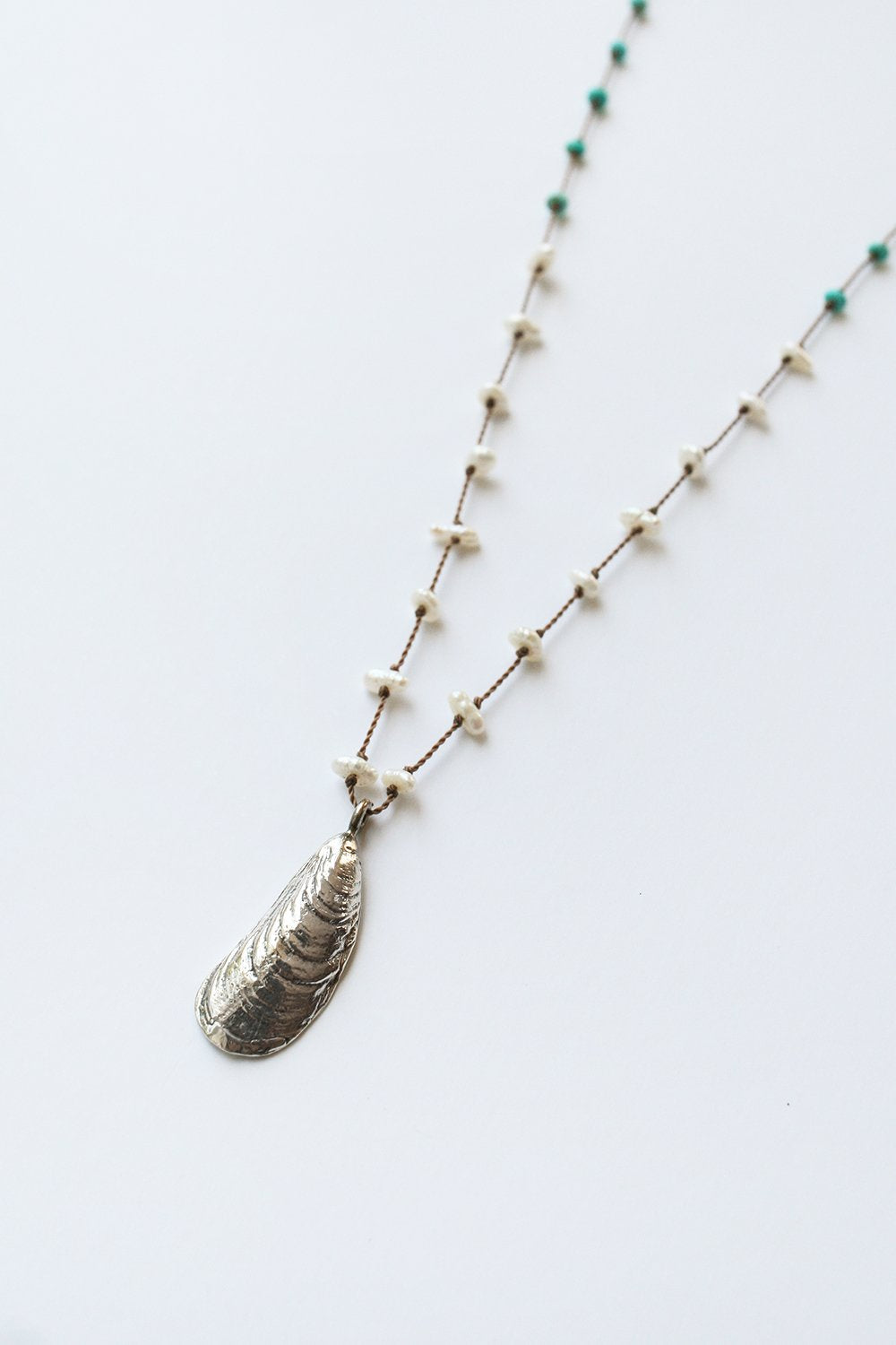 Silver shell pendant necklace with turquoise beads and white accents