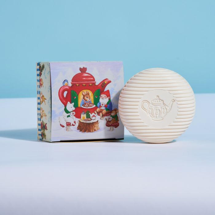 Round white soap bar with teapot emblem, shown with illustrated gnome gift box