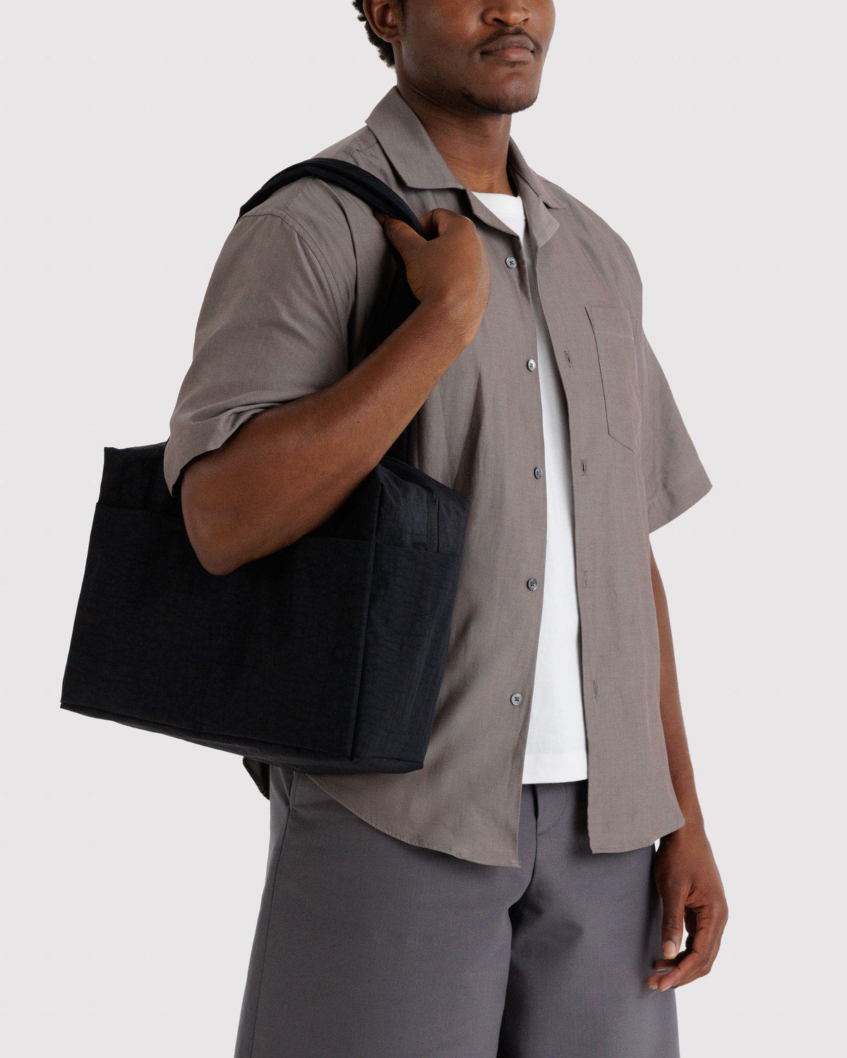 Black cloud tote bag carried over shoulder, two top handles