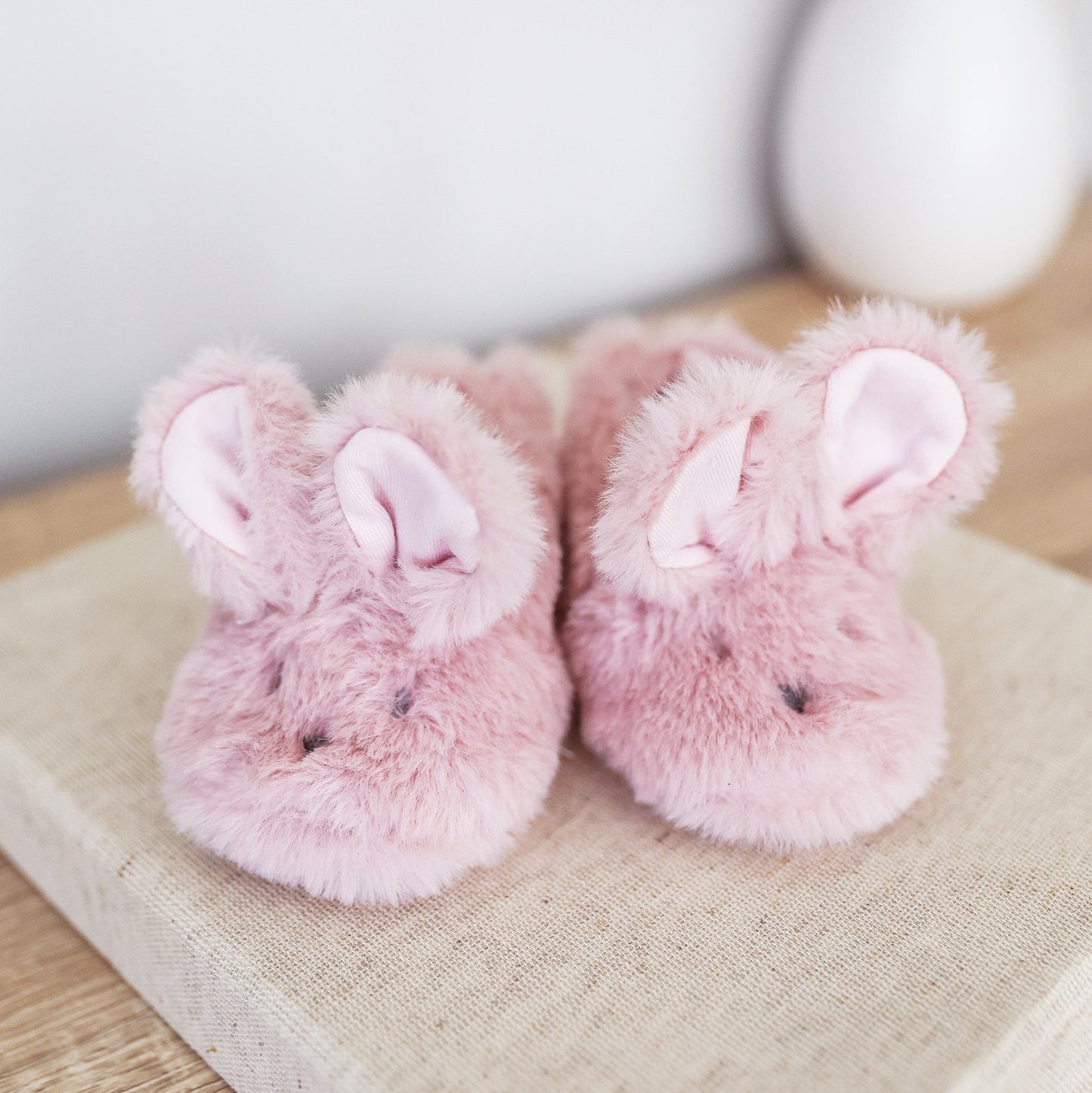 Pink plush bunny booties with padded cuffs and floppy ear detail