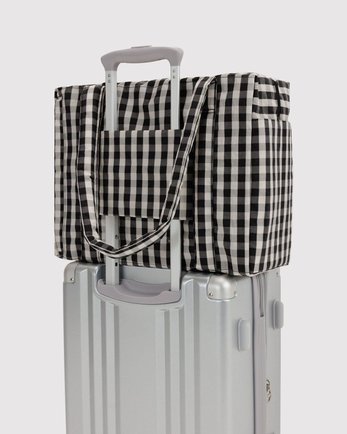 Small Cloud carry-on with black-and-cream gingham tote cover on gray wheeled base