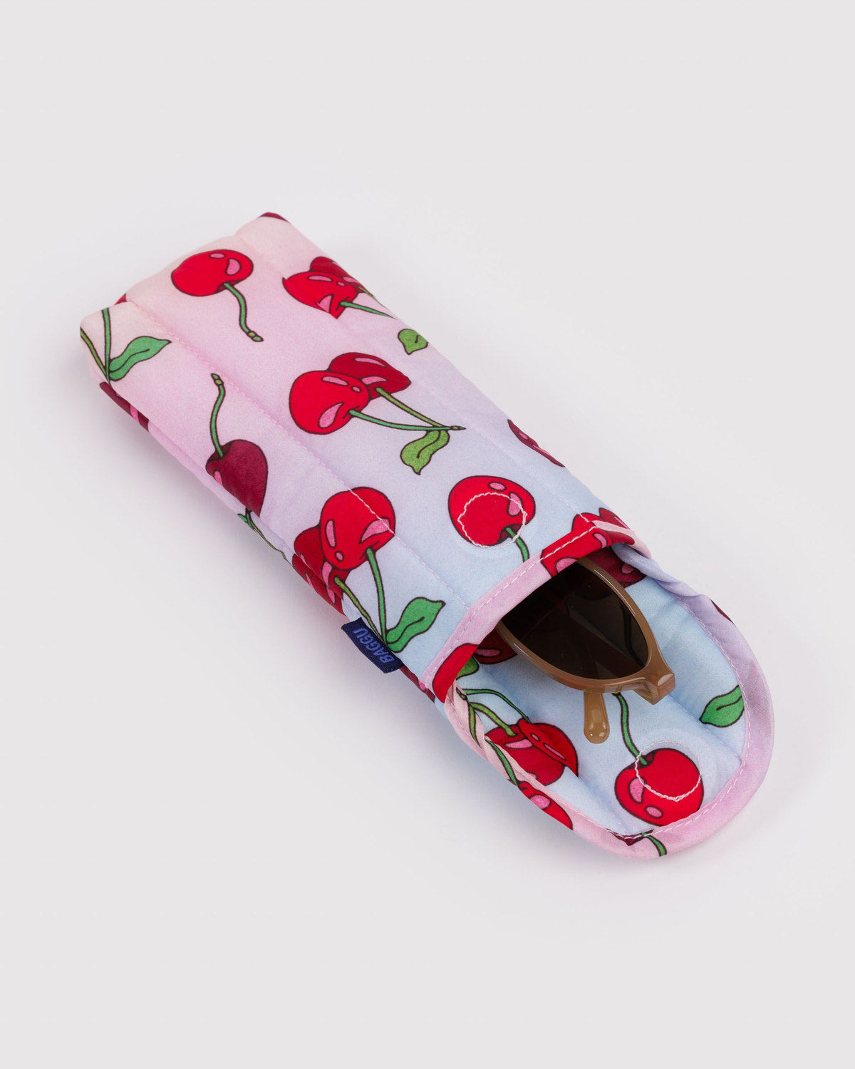 Padded glasses sleeve in pale pink with red cherry print and sunglasses inside