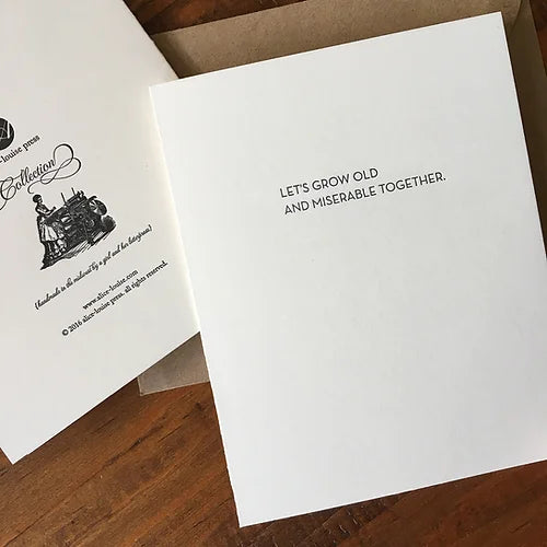 Overlapping white typography print cards with quote and small black logo illustration.