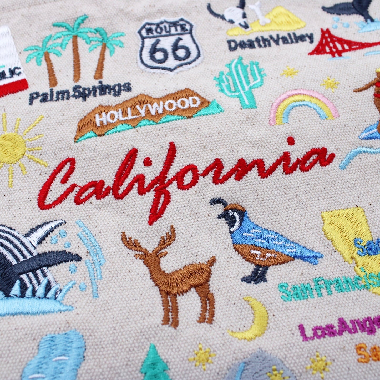 Beige canvas close-up of embroidered “California” text with colorful desert and wildlife icons