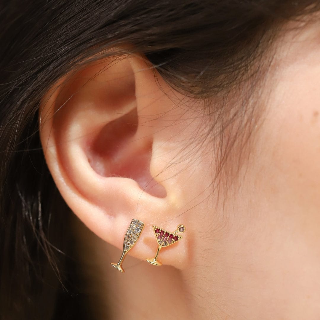 Gold martini glass stud earrings with ombre pink stone accents on ear