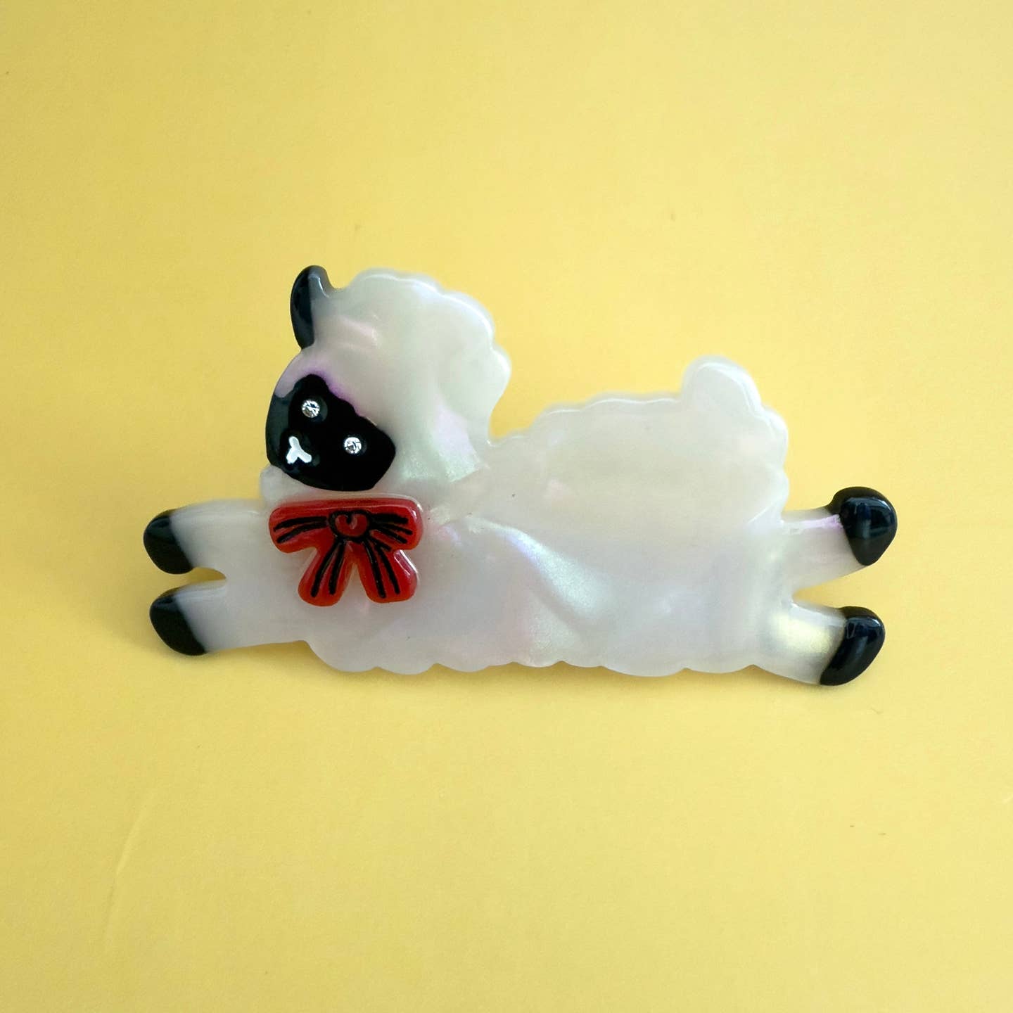 Sheep-shaped alligator hair clip, white fur with black face and red bow