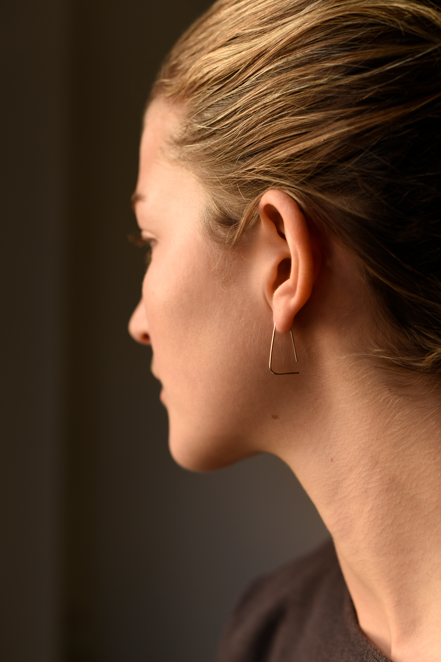 Medium rounded triangle threader earrings on model, gold-tone triangular drops