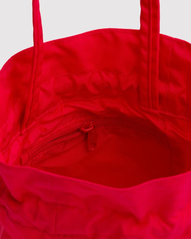 Red nylon drawstring bag interior view with stitched seams and cord pull ties