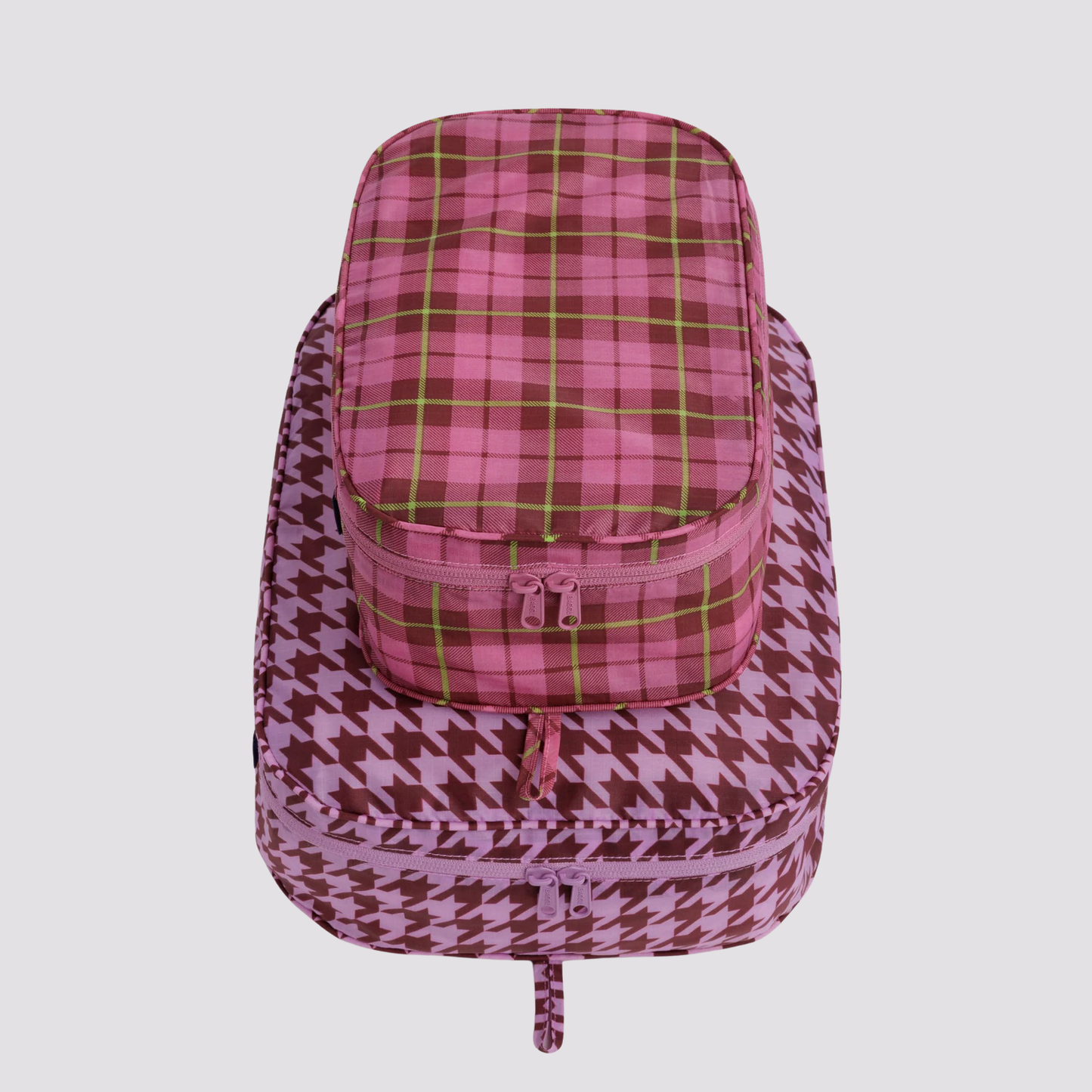 Packing cube set with burgundy houndstooth cube and green-pink plaid top, zip closure.