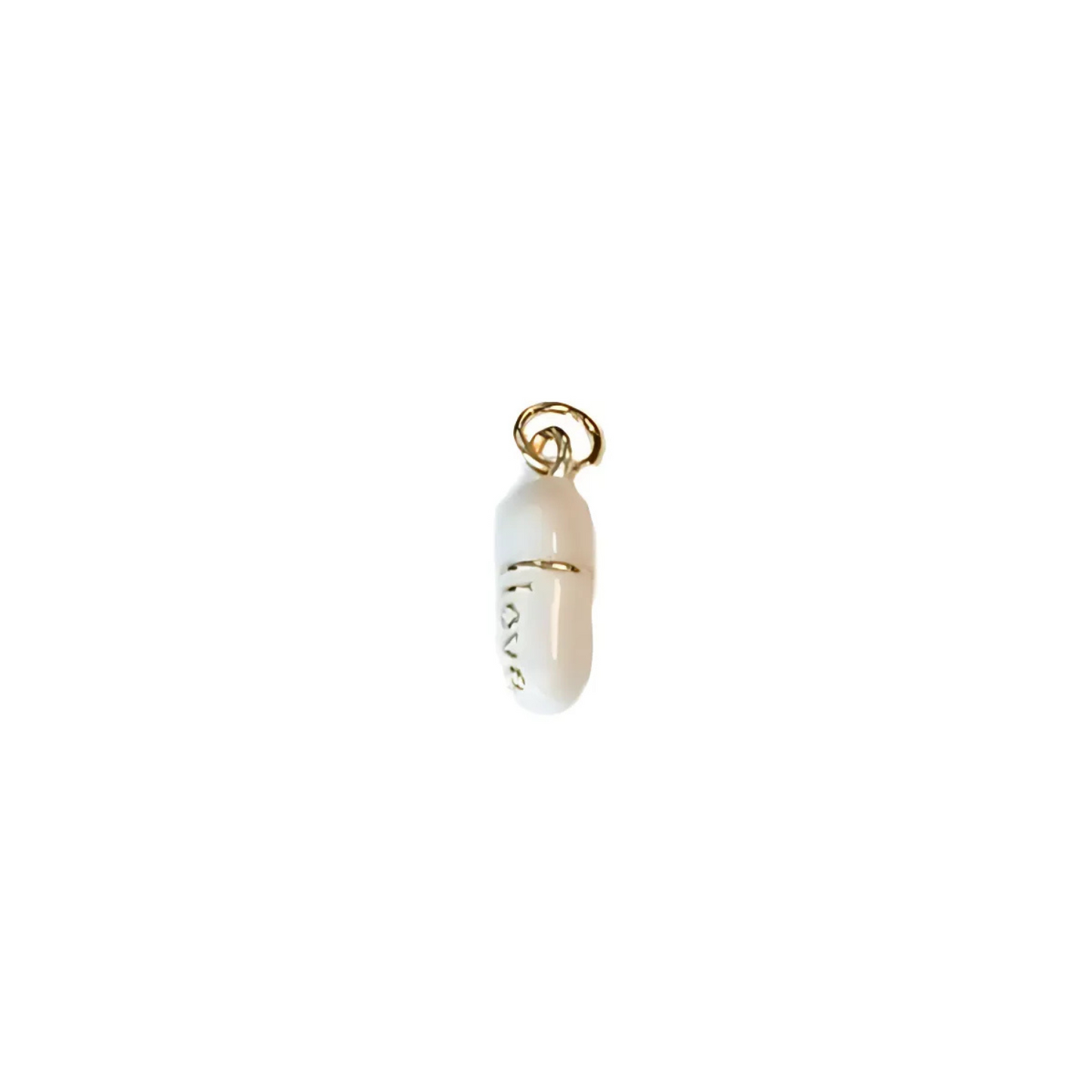 Gold-tone pill charm with white bead, love engraving, and ring bail top