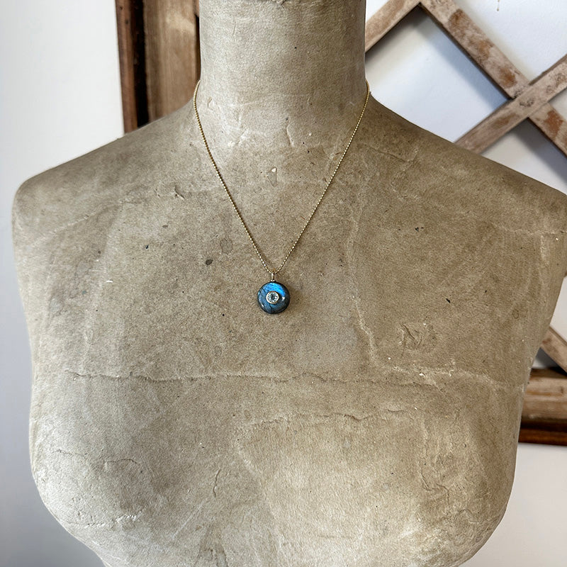 Gold vermeil necklace with round blue labradorite pendant and bezel-set topaz on thin chain.