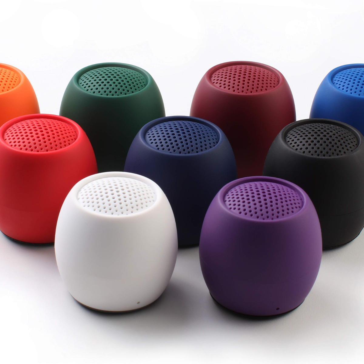 Mini wireless speakers in assorted colors: red, green, blue, white, purple, and black