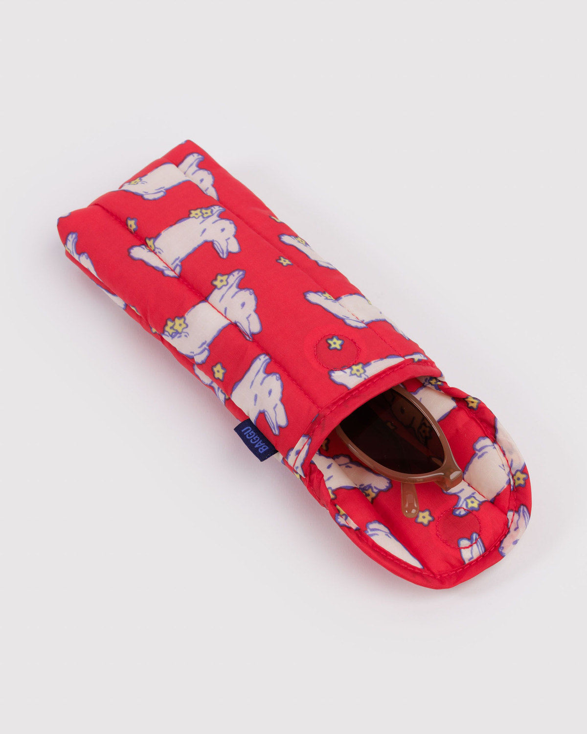 Padded glasses sleeve in red with cute bunny print, angled with sunglasses inside