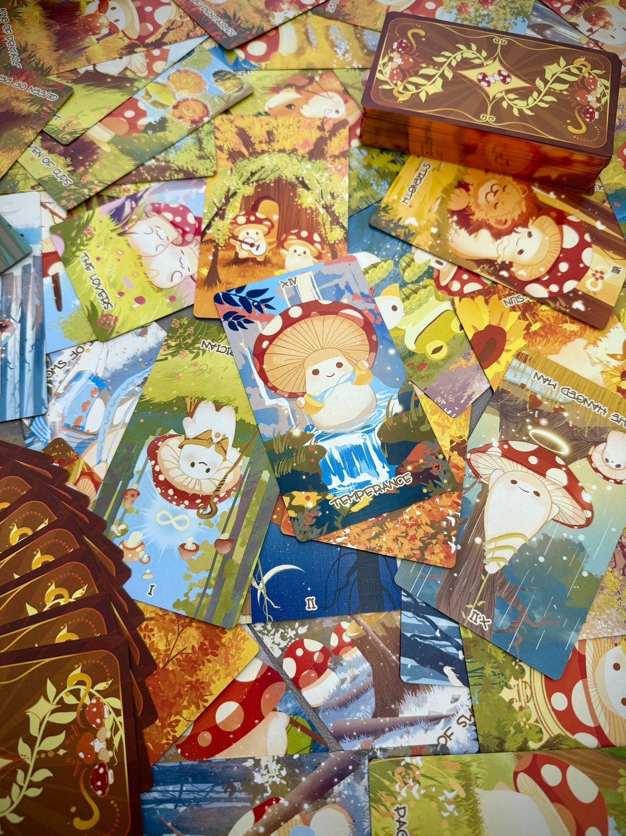 Tarot card deck with mushroom character artwork, scattered cards filling the frame