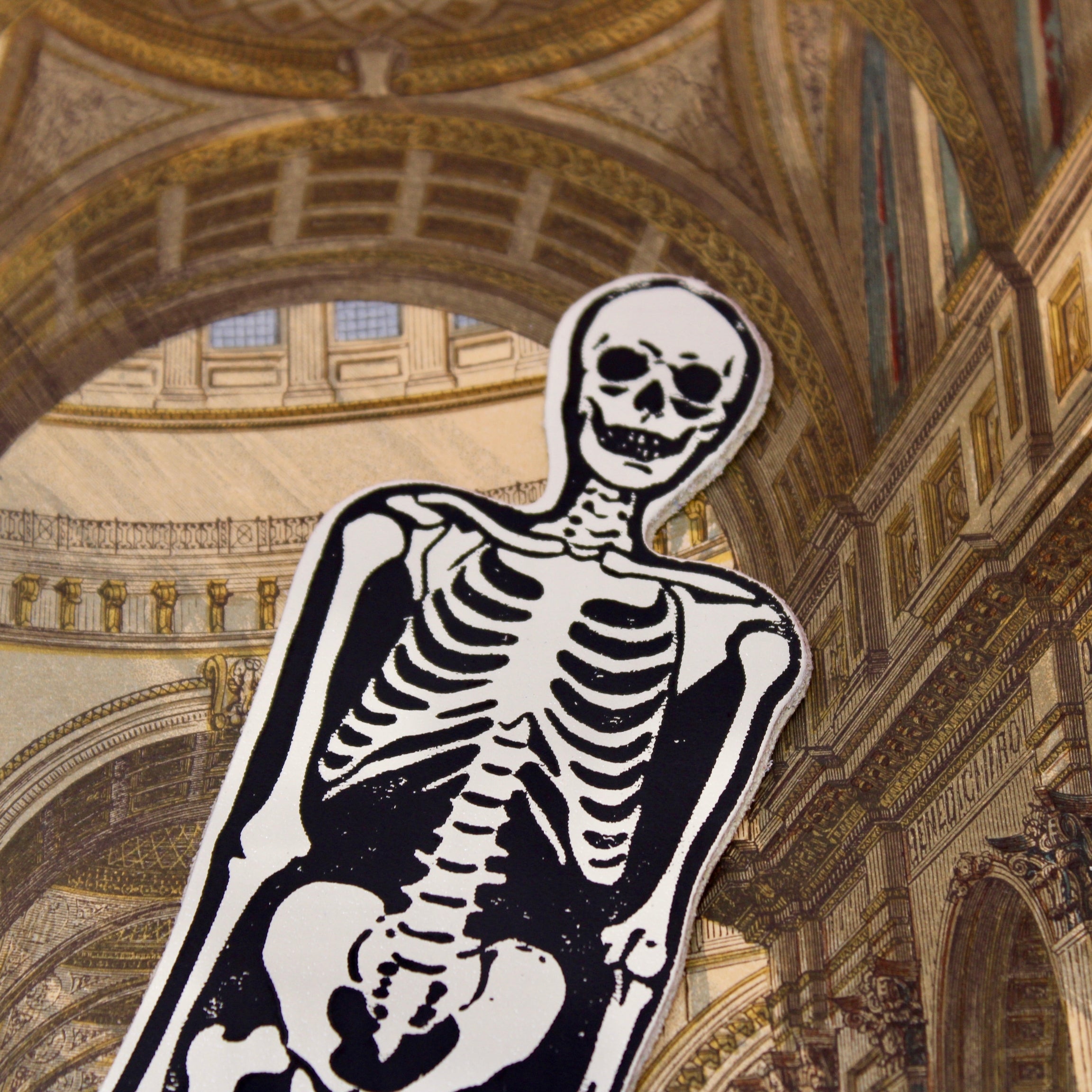 Cream leather skeleton bookmark with black-and-white skull and ribcage design