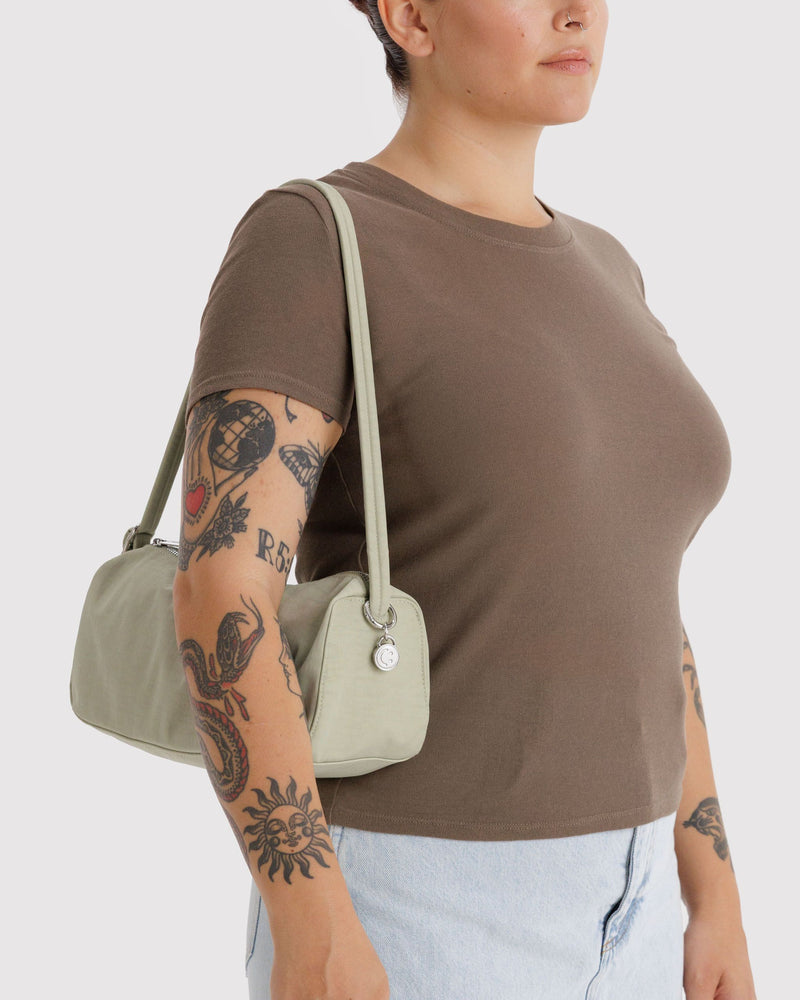 Celadon nylon loaf bag worn over shoulder; curved handle and top zipper.