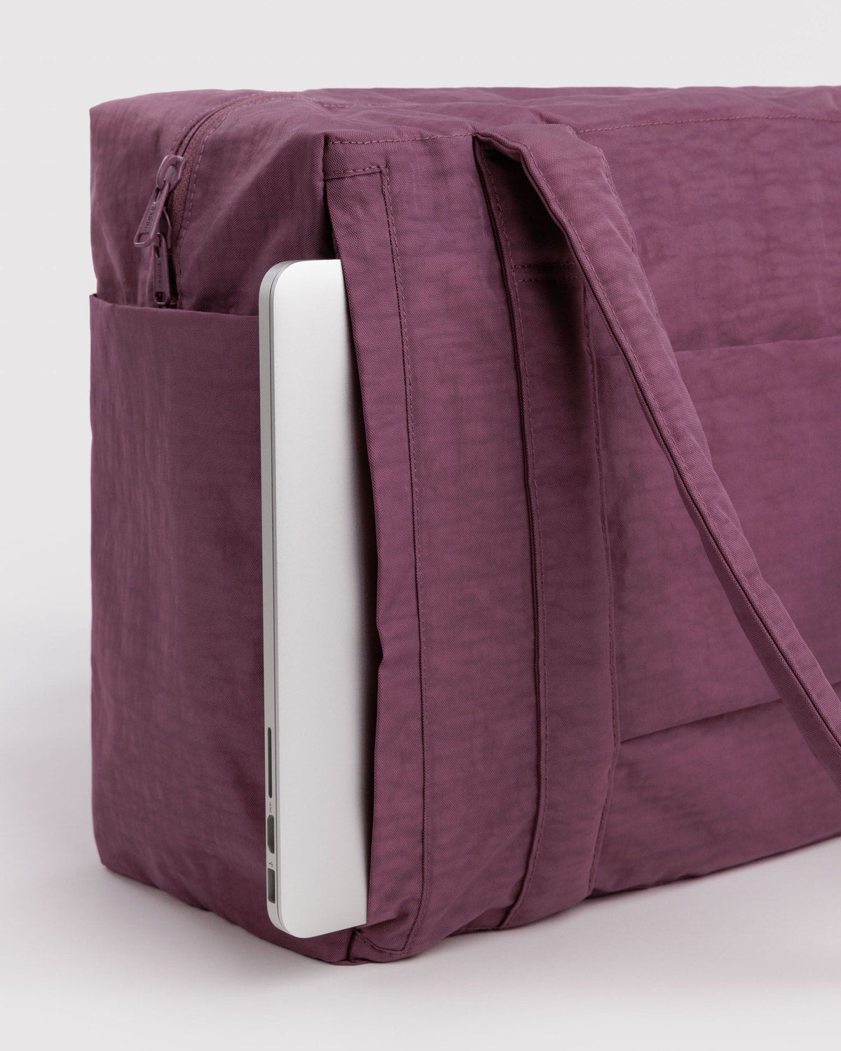 Purple foldable travel tote bag with zipped side pocket and suitcase pass-through panel.