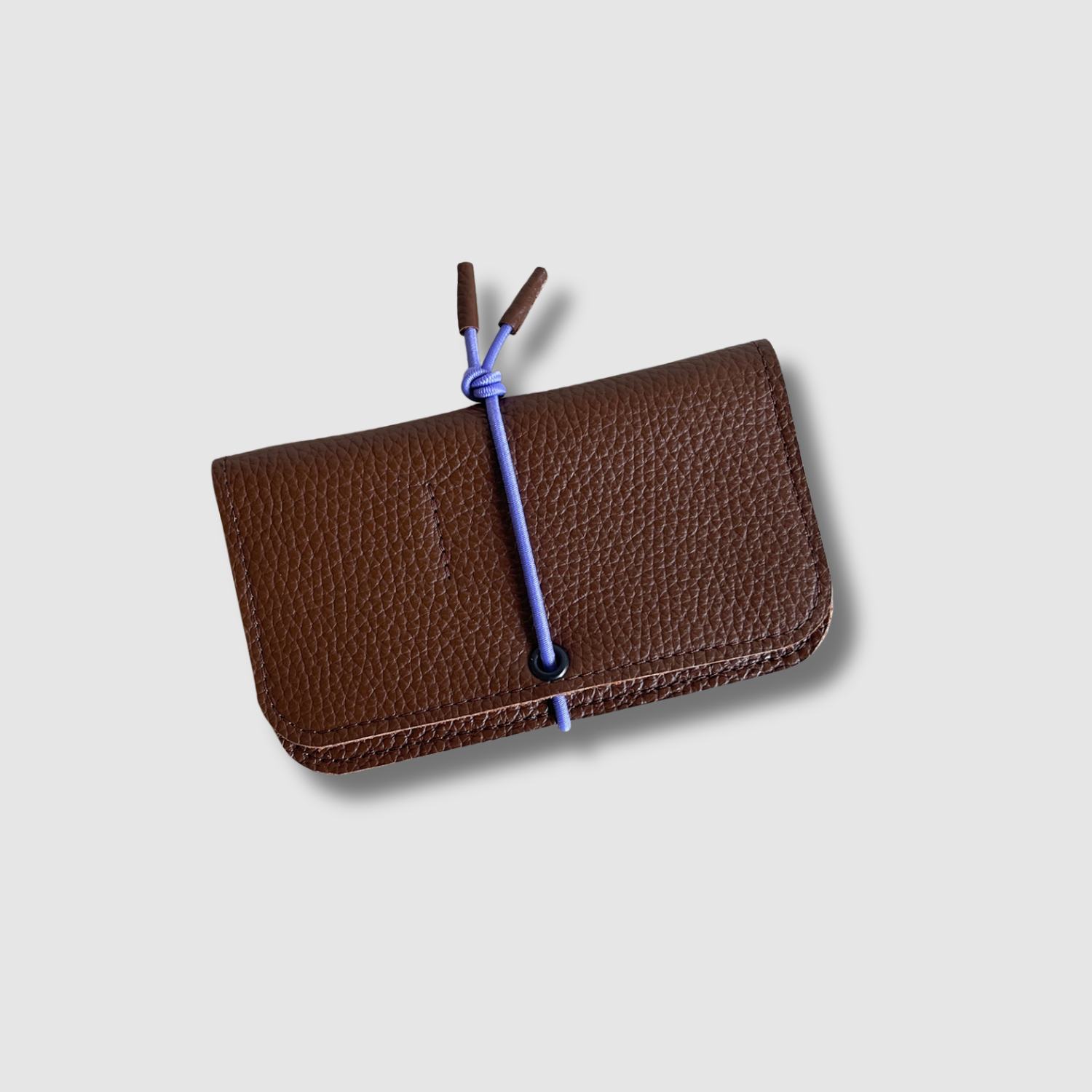 Brown leather knot wallet with front flap and blue cord tie, pebble grain texture