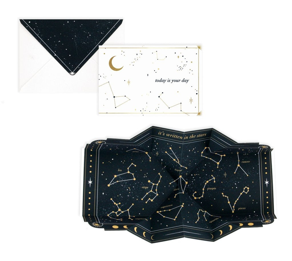 Opened constellation pop-up greeting card with gold line constellations on dark cover