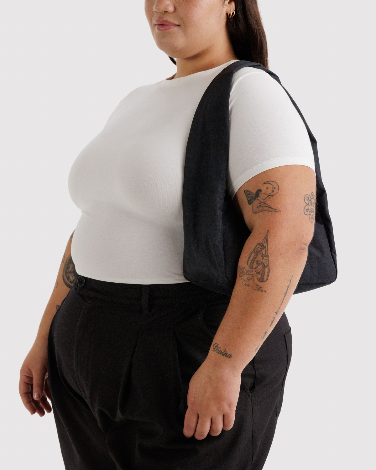 Small nylon meringue bag in black worn over the shoulder