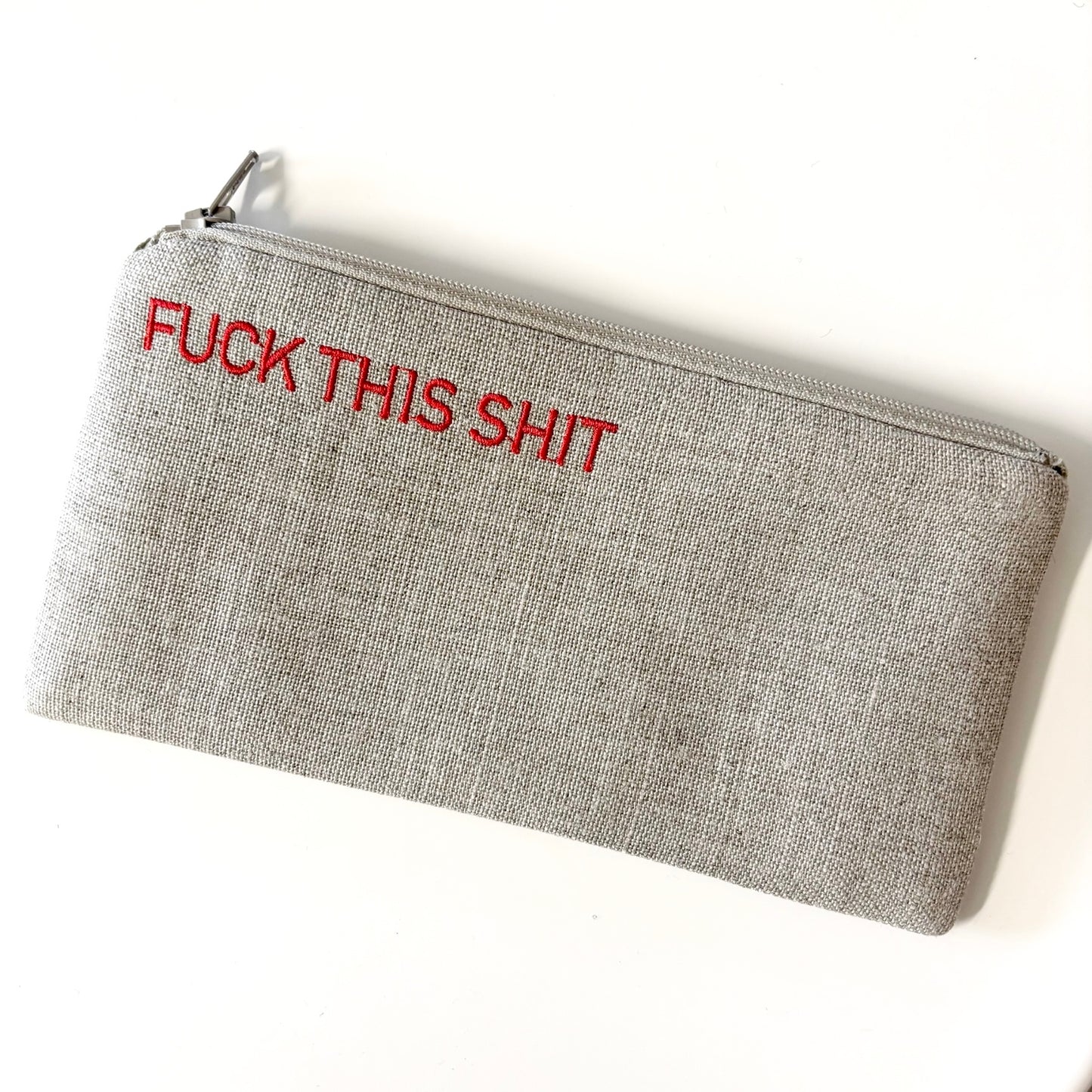 Small gray woven pouch with silver zipper and red printed text