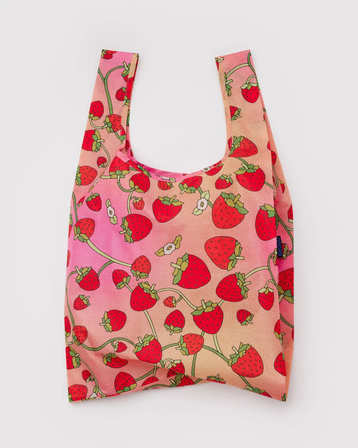 Reusable tote bag in pink with strawberry print and short U-shaped handles.