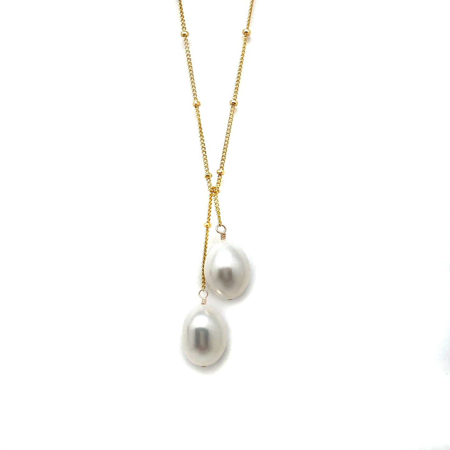 Gold lariat necklace featuring two white pearls on a fine chain lariat
