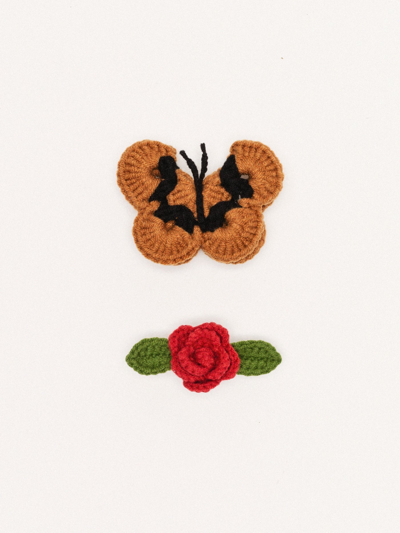 Crochet butterfly hair clip with camel-brown wings and black accents, metal clasp