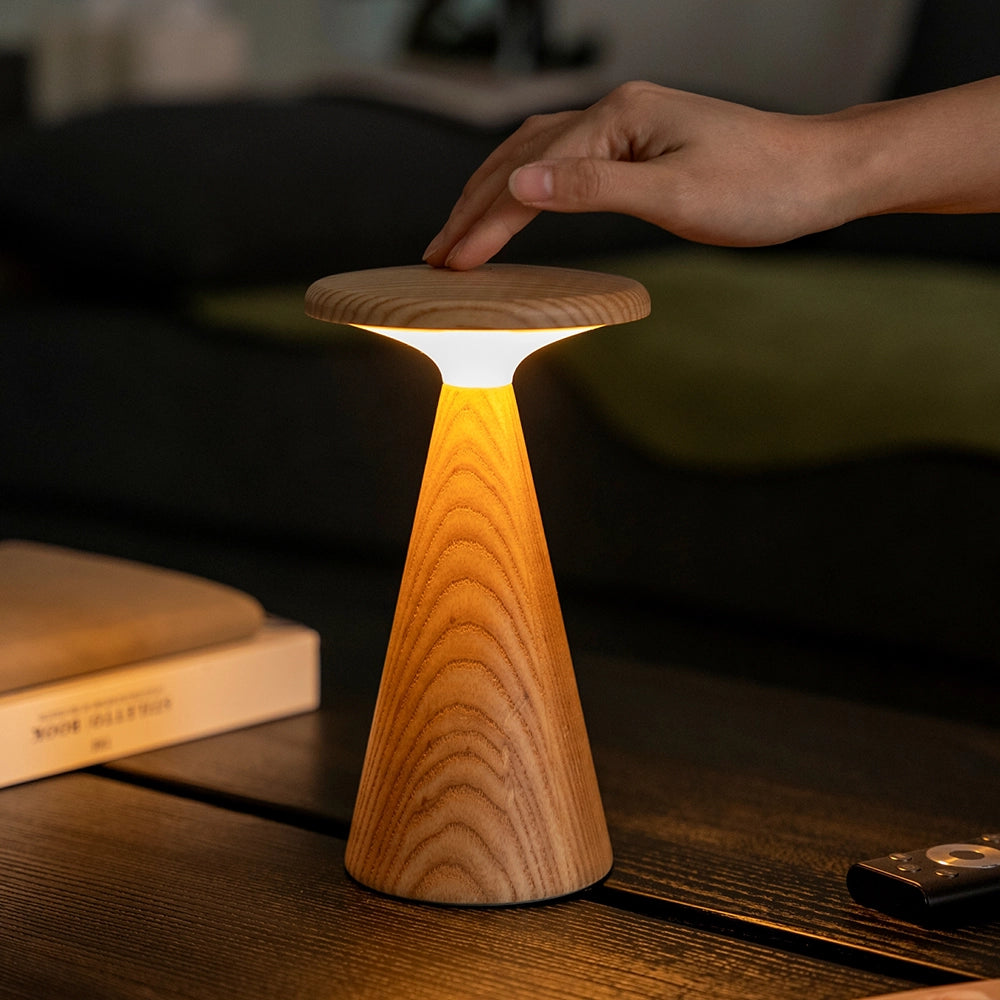 Large wood table lamp with white shade and fluted cylindrical base, warm glow