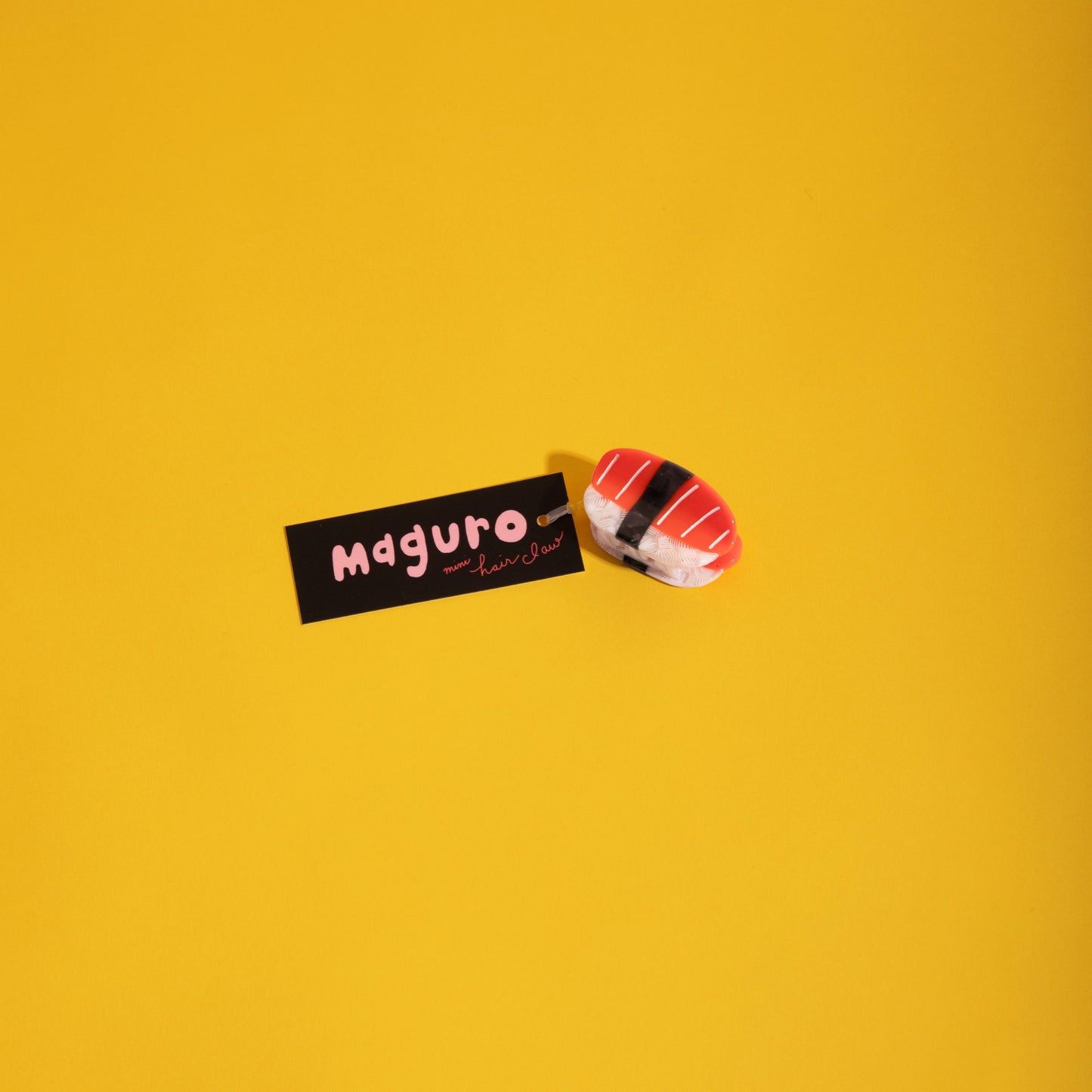 Mini red-and-white striped hair claw clip, angled side view