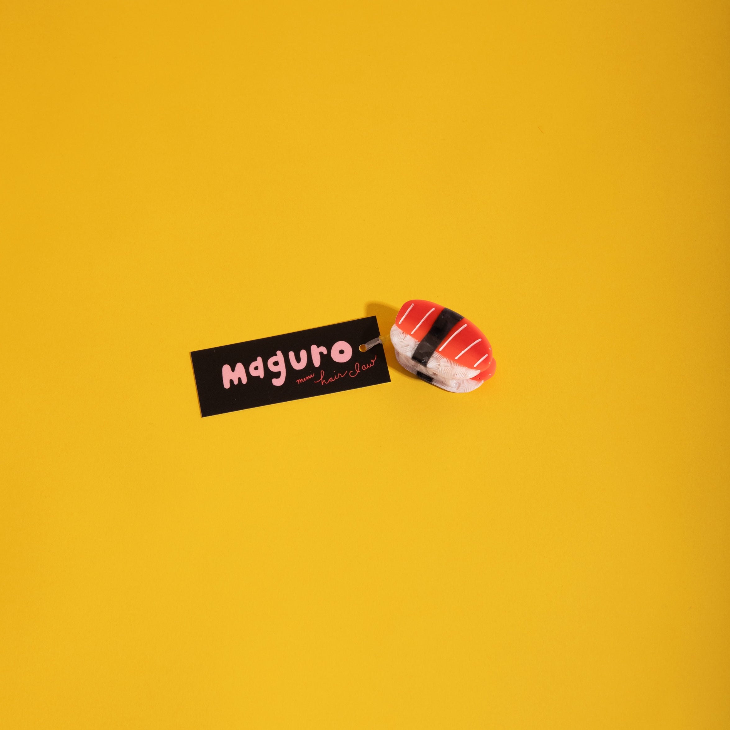 Mini red-and-white striped hair claw clip, angled side view