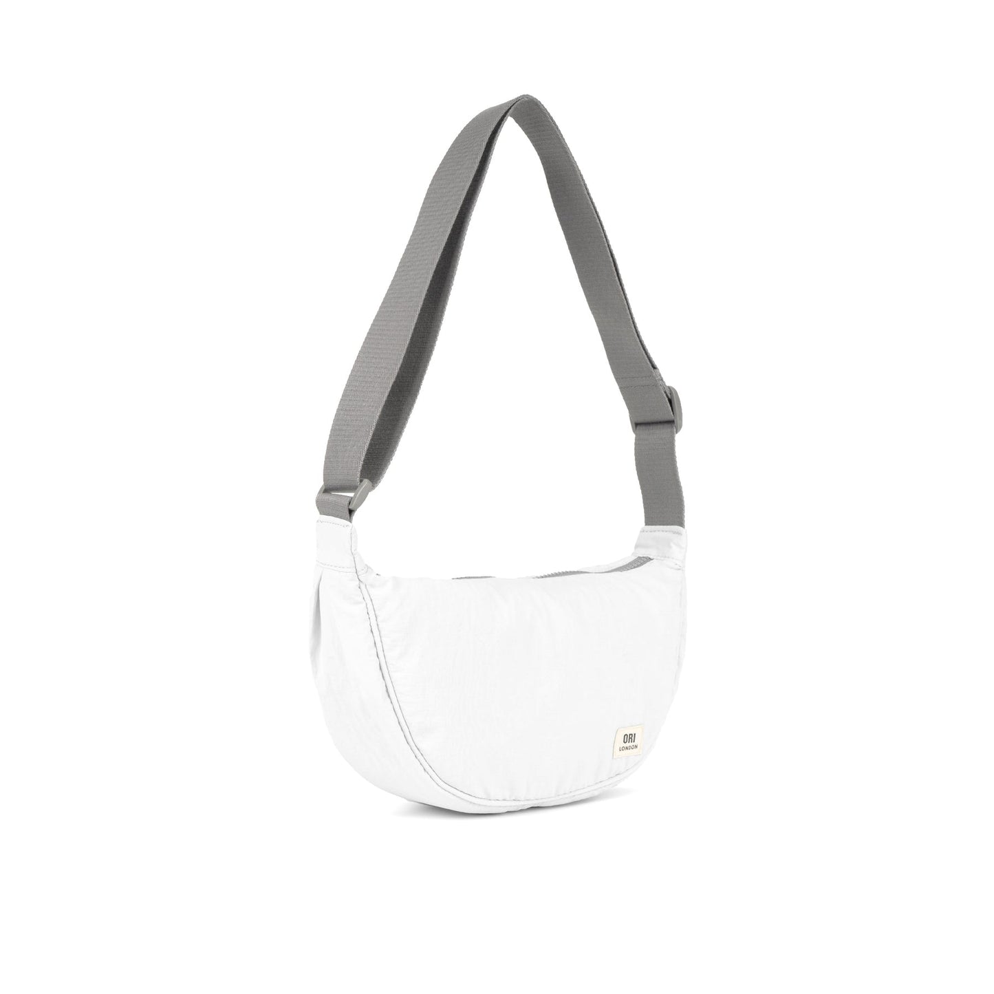 Coconut half-moon crossbody bag with gray webbing handles and zip top.
