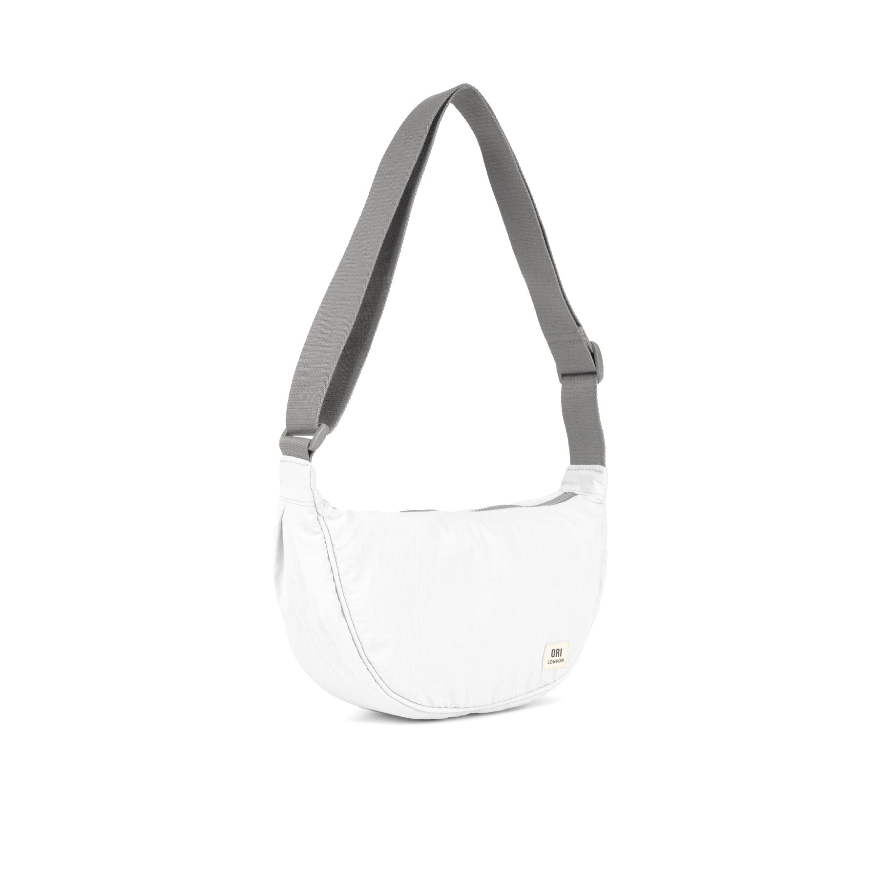 Coconut half-moon crossbody bag with gray webbing handles and zip top.