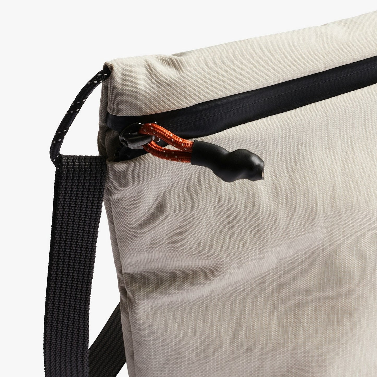 Light ash crossbody bag with black zipper pull and textured webbed shoulder strap