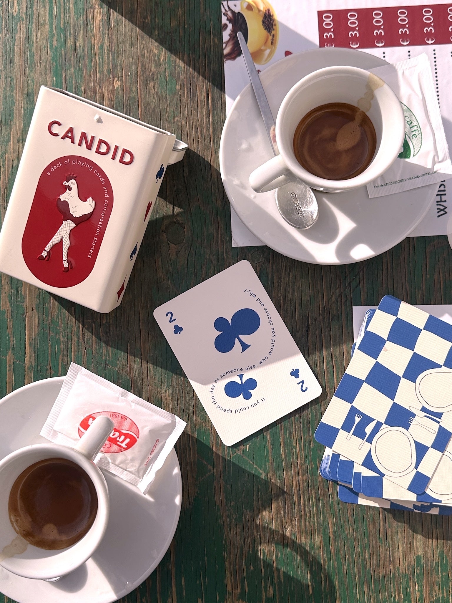 Playing card deck with CANDID tin and face-up playing cards with blue suits