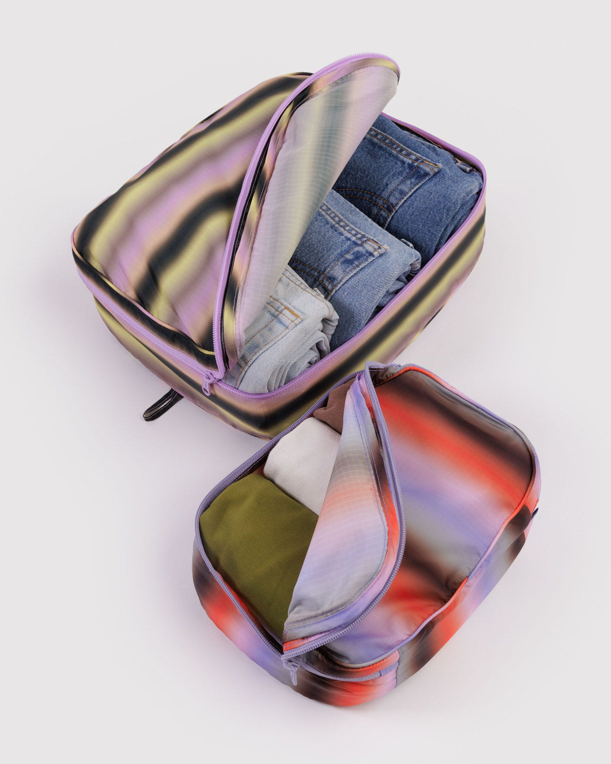 Large packing cubes with iridescent gradient fabric, zip openings, denim and cloth inside