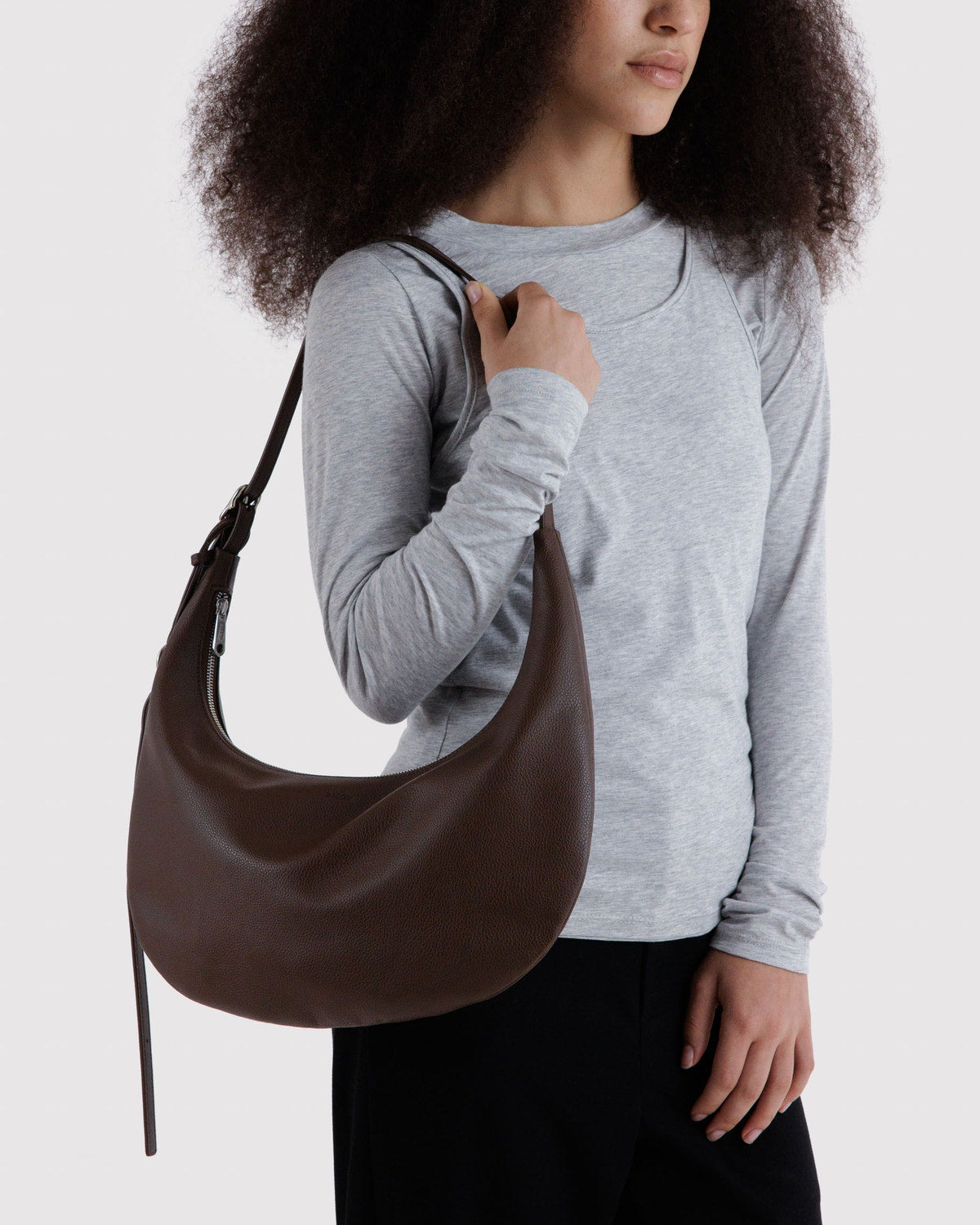 Medium crescent hobo bag in dark brown recycled leather, worn crossbody with long strap