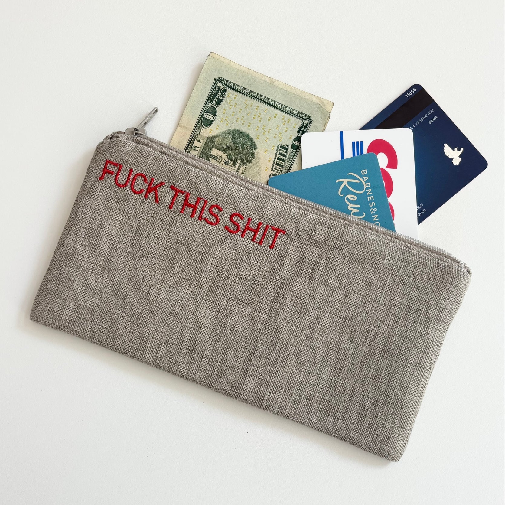 Small gray zippered pouch holding cards and cash in view