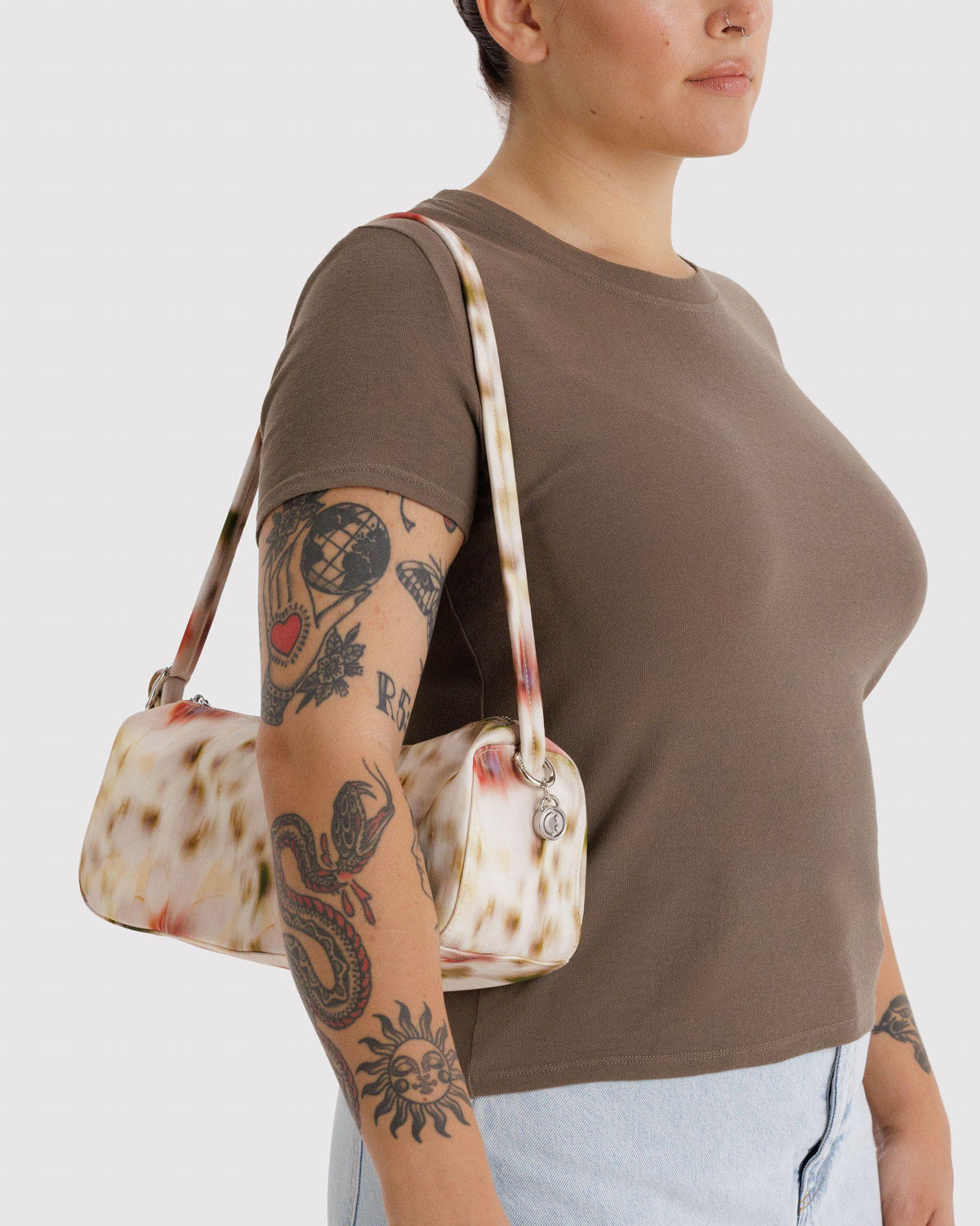 Pastel floral nylon loaf bag with adjustable shoulder strap and metal zipper pull