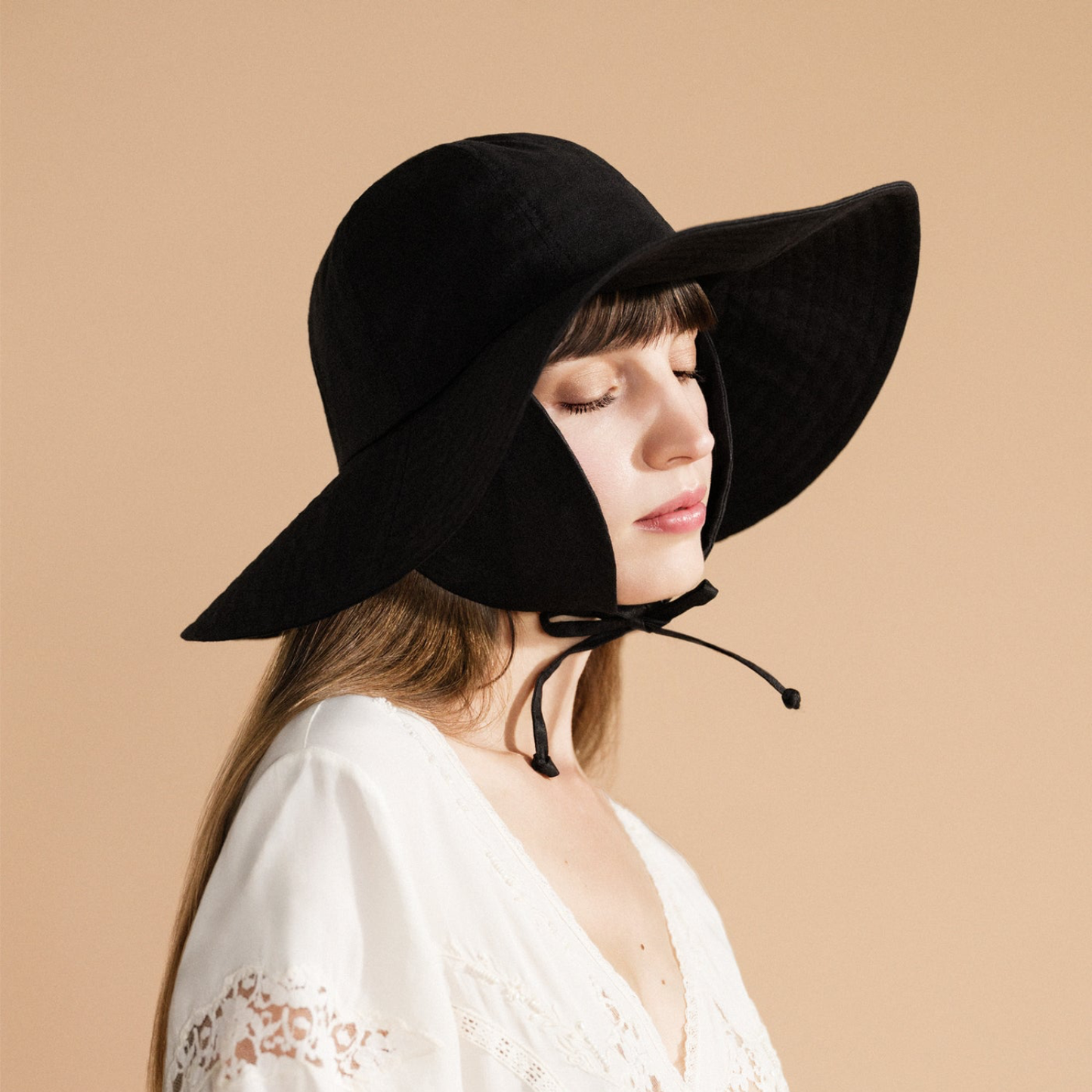 Noona sun hat in black, wide floppy brim with chin tie strings