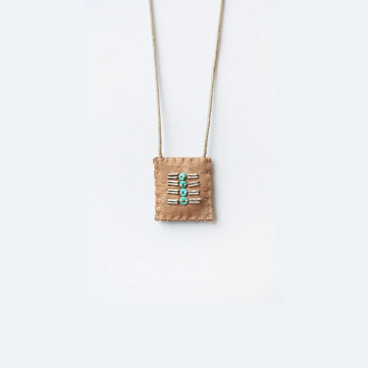Beaded talisman necklace with turquoise bead accents on tan fabric pouch