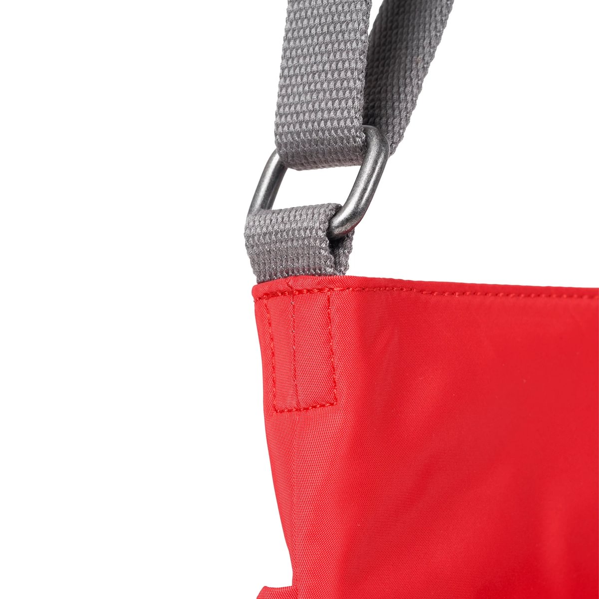 Red sustainable nylon crossbody bag with gray webbing strap and metal D-ring