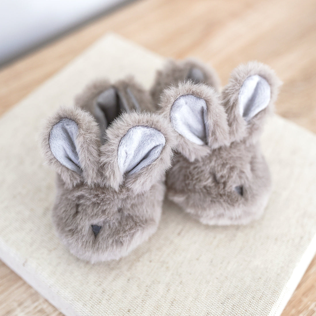 Grey plush bunny booties with raised ear accents and cozy sock-style lining