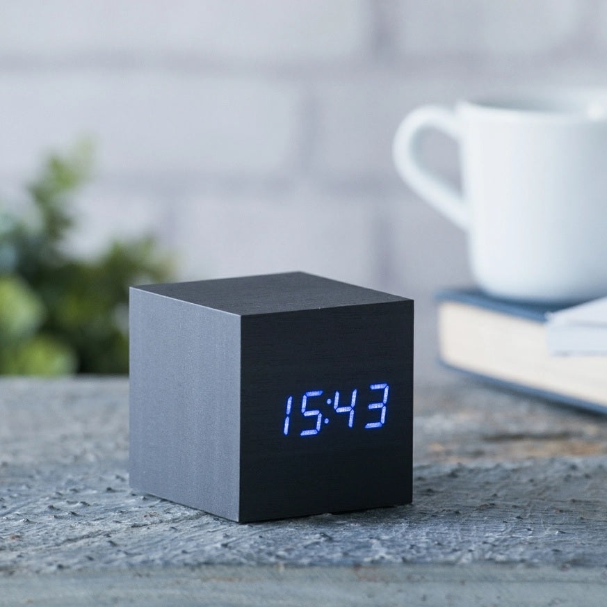 Black cube digital clock with blue LED time display, tabletop design