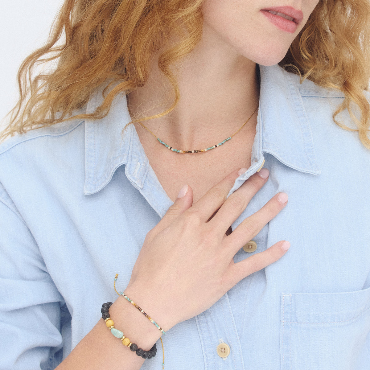 Beaded intention bracelet on wrist with turquoise, black, and gold accents