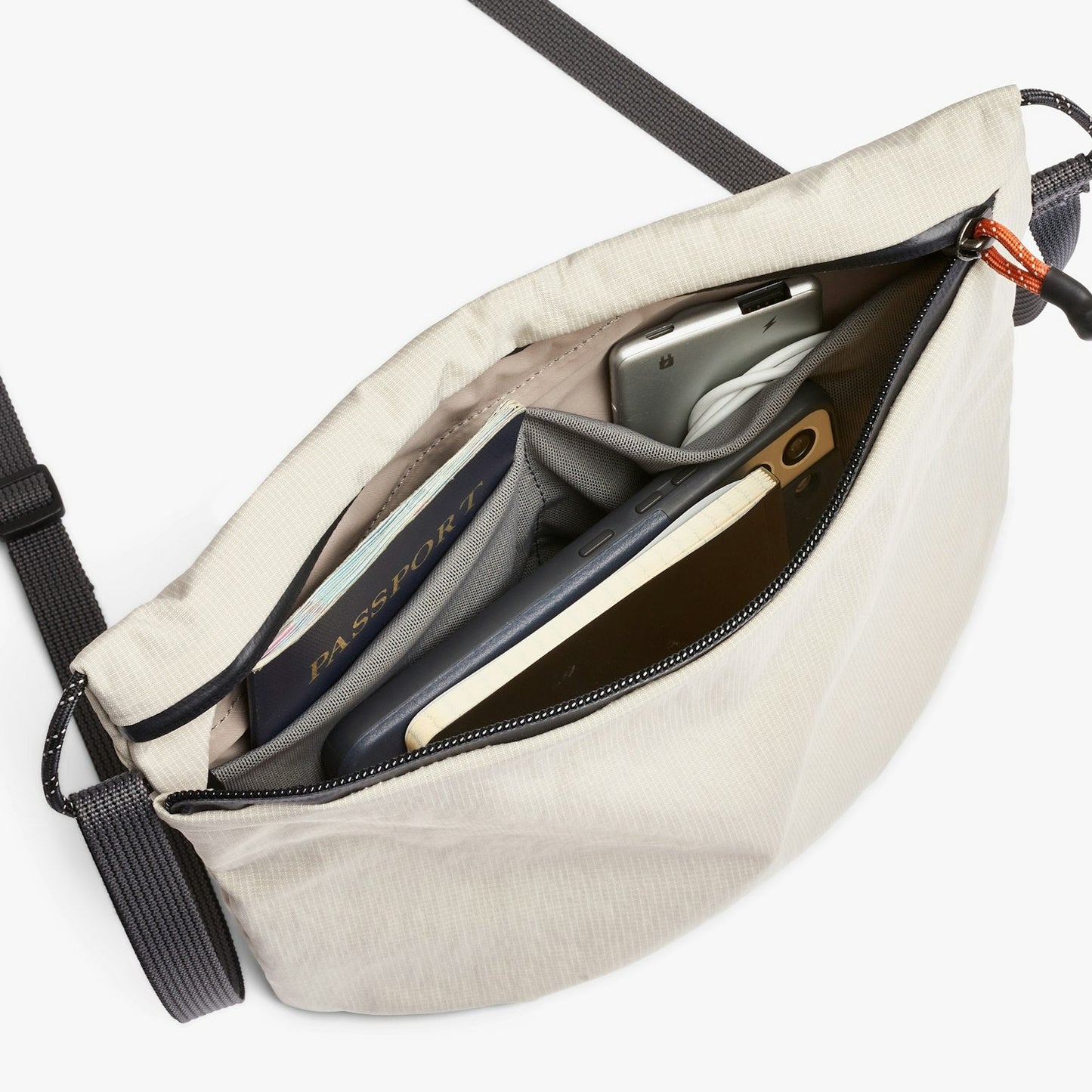 Light ash crossbody bag open to show inner pockets and zip closure